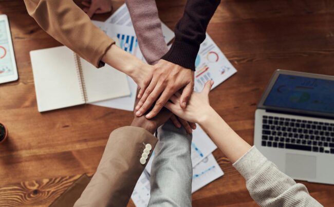 overhead shot of people putting their hands together