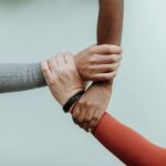 three hands holding each other on a white background